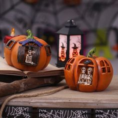 two carved pumpkins sitting on top of a wooden table