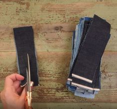 someone using scissors to cut the ends of two pairs of jeans