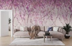 a living room with a couch, table and wallpaper on the walls that has pink flowers painted on it