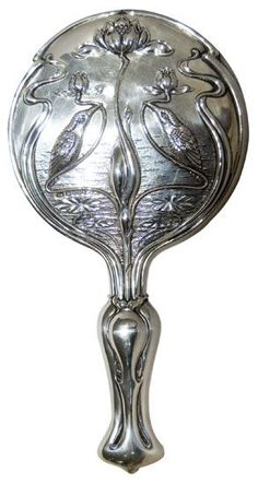 an ornate silver plate with two birds on the front and one bird on the back