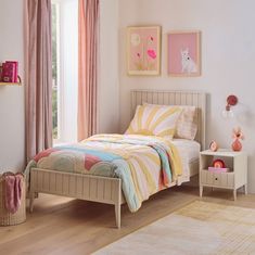 a bed room with a neatly made bed and pink curtains