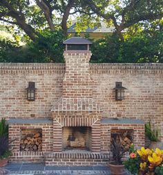 an outdoor fireplace surrounded by potted plants and trees