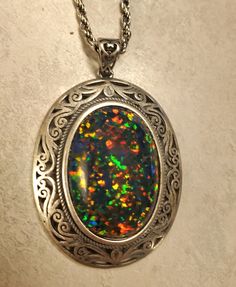 "Beautiful Black Opal Vintage Style Necklace, Huge 18x25mm Lab Created Favorite Opal, See Video! Photos Taken In Natural As Well As Indoor Lighting. Antiqued Sterling Silver Vintage Style Pendant, 20\" Matching Sterling Chain. Gift Box Included.  *This One Is For Lovers Of Big Bold Jewelry, Make Sure Recipient Is That Person! I Have This Stone In A Simple Pendant Also" Multicolor Hallmarked Necklaces As Gift, Multicolor Hallmarked Necklace For Gift, Oval Multicolor Jewelry For Formal Occasions, Multicolor Cabochon Round Pendant Jewelry, Multicolor Necklace With Large Oval Pendant, Spiritual Multicolor Cabochon Necklace, Ornate Multicolor Necklace For Gift, Multicolor Necklace With Large Stone For Gift, Multicolor Oval Pendant For Jewelry Making