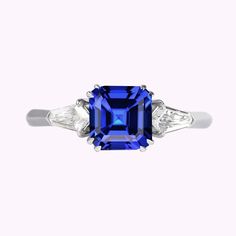 a blue sapphire and diamond ring with three diamonds on the side, set in white gold