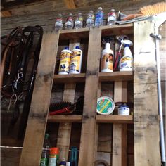 a wooden shelf filled with lots of different types of paint and other things on top of it