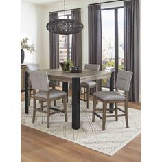 a dining room table with four chairs and a chandelier hanging from the ceiling