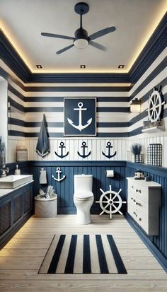 a bathroom decorated in blue and white with an anchor theme on the wall above the toilet