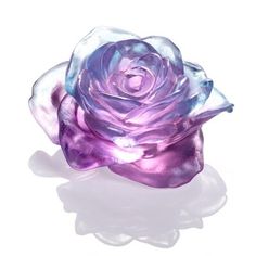 a purple rose sitting on top of a white surface