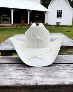 Baby features the daintiest of pearl bows adorning the a clean white hard canvas cowboy hat. Proudly American Made. Our hats are manufactured in Mexico and details added by hand in Los Angeles, CA using the highest quality materials. Sizing S/M 19in-22.75in | 48cm-57.5cm L/XL 19.5in-23.25in | 49.5cm-59cm *Please allow up to 2 weeks for production and shipping. White Cowboy Hat, Garden Party Bridal Shower, Parisian Summer, Bridesmaid Duties, Baby L, Bridal Fabric, Bach Party, Welcome To The Party, Cowgirl Hats