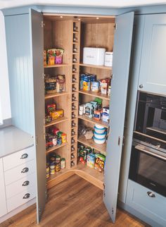 an open pantry with lots of food in the cupboards and on the floor next to it