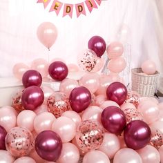 pink and white balloons are in the middle of a table