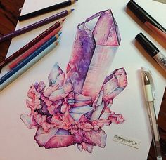 some pencils are laying on top of a piece of paper with an image of a crystal