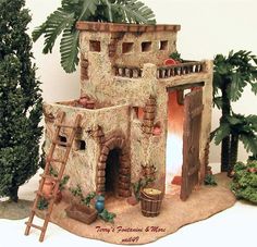 a miniature house made out of clay with trees in the back ground and plants on either side