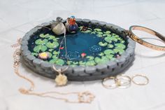 a ring sits on top of a pond filled with water lilies and two ducks