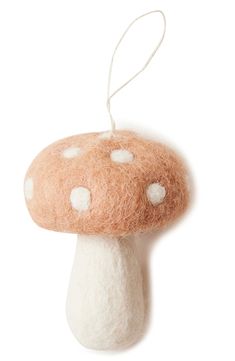 a mushroom ornament hanging from a string on a white background with polka dots