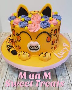 a yellow cake with pink and blue flowers on top