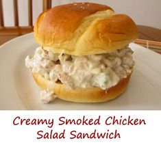 a chicken salad sandwich on a white plate with the words creamy smoked chicken salad sandwich