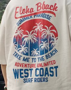 a man wearing a white shirt with red, blue and green palm trees on it