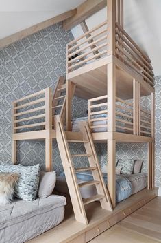 a bunk bed with stairs in the middle of it and pillows on the floor below