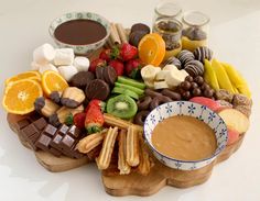 a wooden platter filled with fruit and chocolate