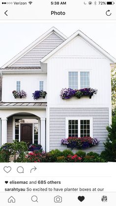 a house with flowers in the window boxes on the front and side of the house