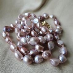 vintage keshi pearl necklace - pink rainbow ocean pearl necklace - vintage baroque keshi pearl necklace - 18kp hand knotted pearl necklace - fine lavender pink pearl necklace 18kp gold clasp - so beautiful - these pearls hold truly amazing colors - pink to lavender with iridescent highlights of gold, blue and green - the pearls are ocean pearls - a keshi pearl is unusual as it has no center and is made mostly of nacre - this gives the pearls an amazing light bright quality - the pearls are various shapes generally 7 to 8mm in diameter - individually knotted in between each - the clasp is unique - first it hooks then slide locks into a ridged ball - it is 18 karat gold plated - stamped 18kgp - the necklace is about 25 inches long  - excellent vintage condition - hand knotted lavender pink k Classic Pink Pear Shaped Jewelry, Classic Pink Pear-shaped Jewelry, Handmade Baroque Pearl Round Jewelry, Handmade Baroque Pearl Jewelry, Handmade Oval Pearl Necklace As Gift, Handmade Oval Pearl Necklace For Gift, Single Strand Baroque Pearl Briolette Jewelry, Handmade Oval Pearl Necklace Gift, Delicate Baroque Pearl Beaded Jewelry