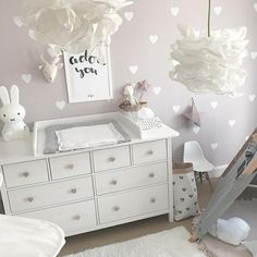 a baby's room with white furniture and hearts on the wall