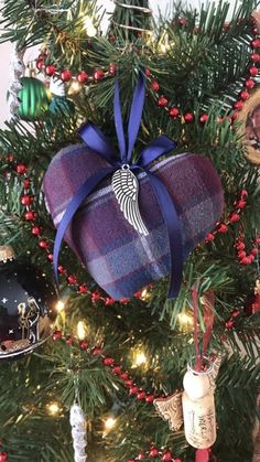 an ornament hanging from the top of a christmas tree with ornaments around it