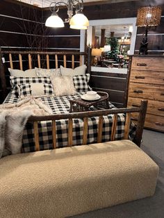 a bed sitting in a bedroom next to a dresser and chair with pillows on it