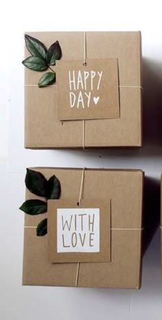 two brown boxes with green leaves on them and the words happy day written in white