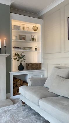 a living room filled with furniture and a fire place next to a white fireplace mantel