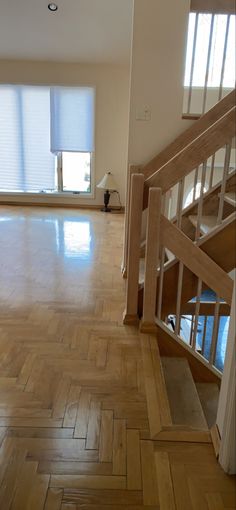 an empty room with wooden floors and windows