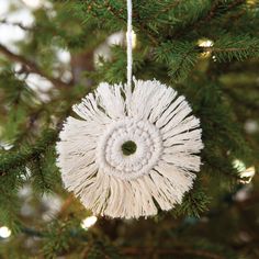 a white ornament hanging from a christmas tree