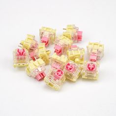 many small yellow and pink switches on a white surface