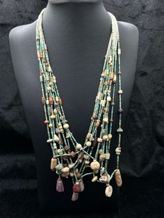 a necklace with beads and stones on a mannequin