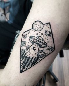 a black and white tattoo on the arm of a man with an alien ship in space