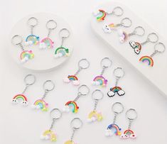 several key chains with rainbows and clouds on them are shown in front of each other