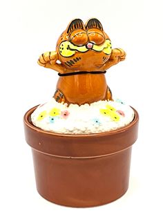 a ceramic cat sitting on top of a potted plant