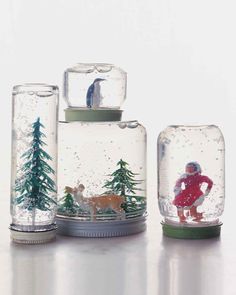 three snow globes with miniature figurines in them