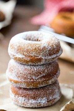 three donuts stacked on top of each other with sugar sprinkled on them