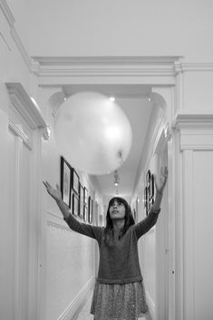 a woman standing in a hallway with her arms outstretched