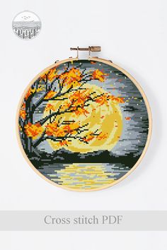 a cross stitch pattern with an image of a tree and the moon in autumn colors