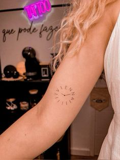 a woman's arm with a clock tattoo on the left side of her arm