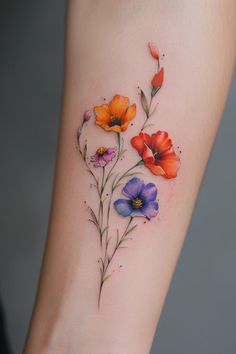 a woman's arm with colorful flowers on the left side of her body and watercolor