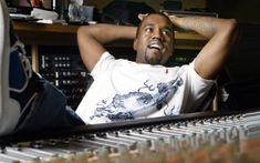 a man sitting in front of a mixing desk with his head resting on his hands