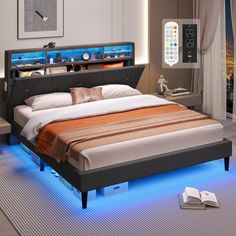 a bed that is sitting in the middle of a room with blue lights on it