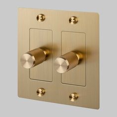 two dimmers are on the side of a gold plated wall light switch