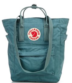 From Fjallraven&#x2C; the Kanken Convertible Totepack Backpack features: Vinylon F: 100% vinylal A tote version of Fjällräven’s iconic backpack from 1978Can be carried on the shoulder or as a backpackMade from hardwearing&#x2C; water-resistant Vinylon F fabricTop-loaded zippered main compartmentInside 13" laptop/tablet sleeve with padded baseIncludes a seat pad stored in an inside pocket in the back of main compartmentWebbing shoulder strap Kanken Totepack Outfit, Fjallraven Kanken Totepack, Fjallraven Totepack, Uni Bag, College Backpack, Classy Fashion, Tablet Sleeve, Sandals For Sale, Kanken Backpack