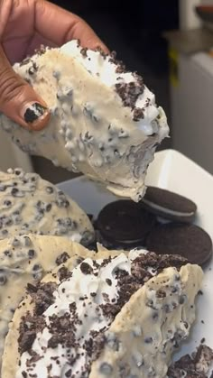 someone is holding up some cookies and cream cake