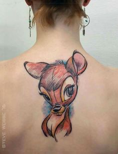 the back of a woman's neck with an animal tattoo on her left shoulder